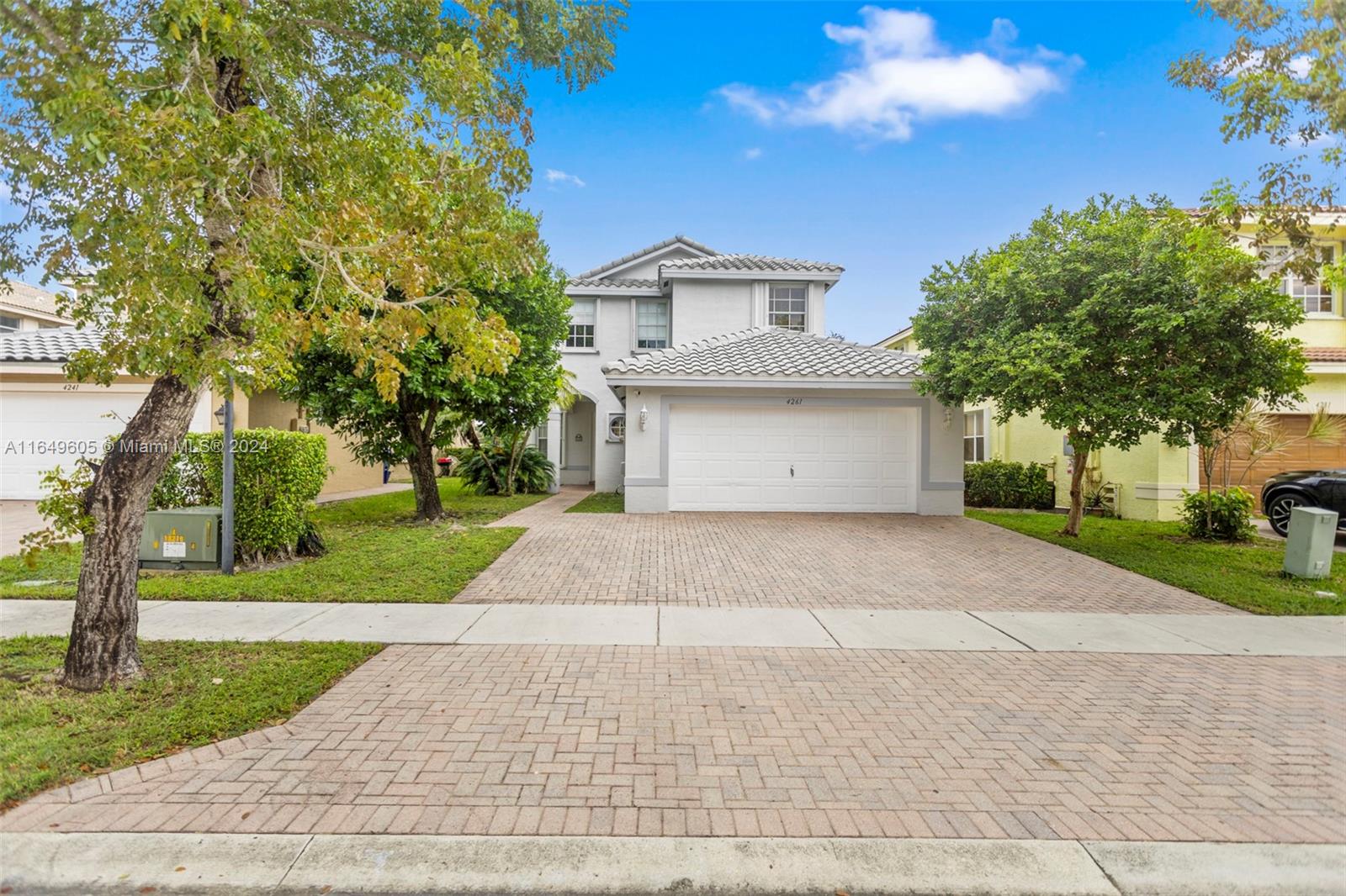 a front view of a house with a yard and trees