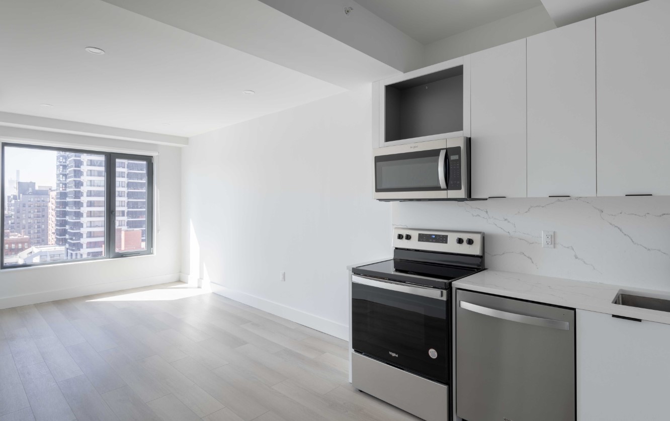 a kitchen with stainless steel appliances a stove a microwave and white cabinets