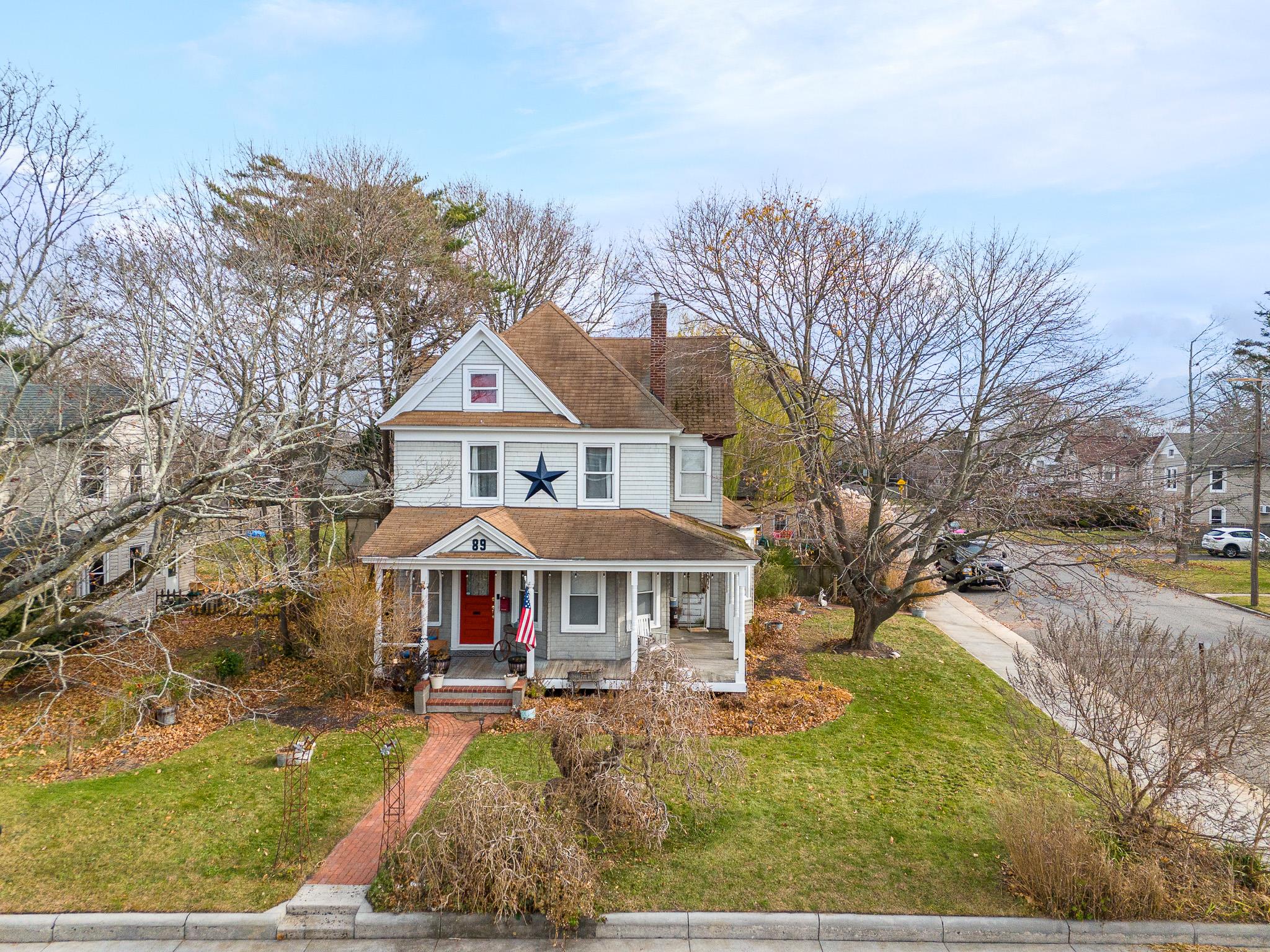 Victorian-style house with covered porch and a front yard