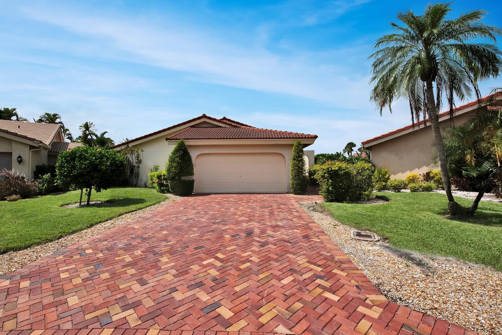 a front view of a house with a garden and yard