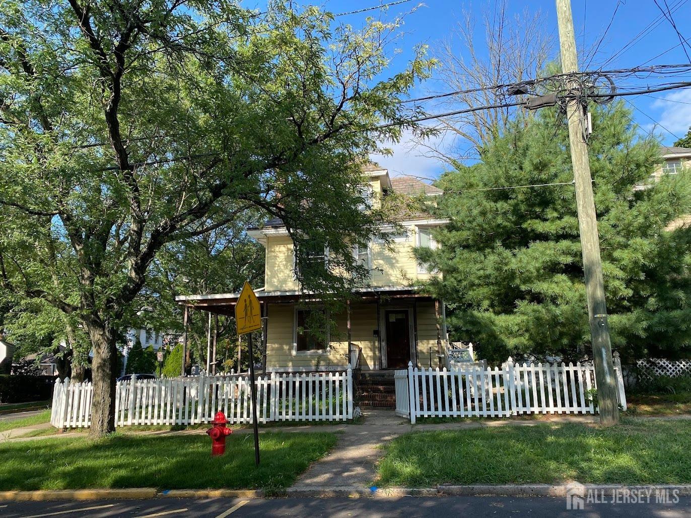 a view of a house with a small yard and wooden fence