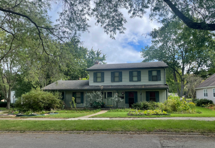 a front view of a house with a garden