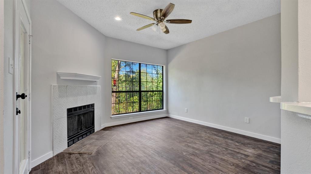 an empty room with windows and fireplace