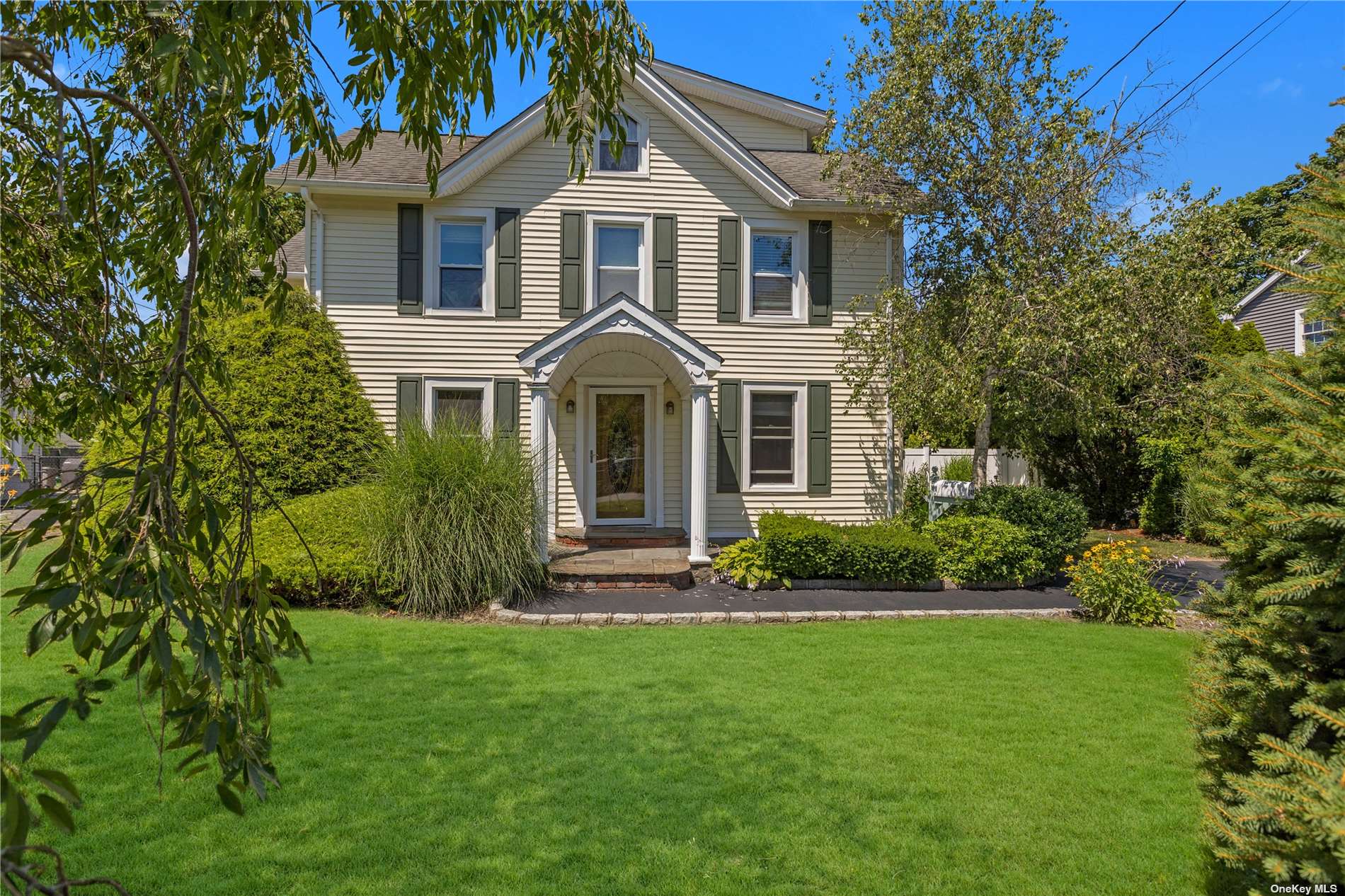 a front view of a house with a yard and potted plants