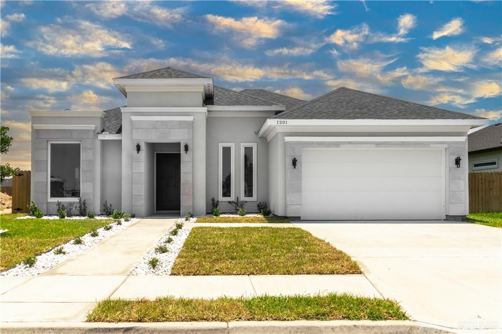 Prairie-style home featuring a garage and a front lawn