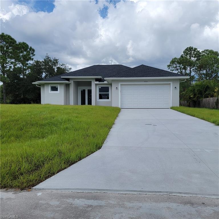 View of front of home with a front yard and a garage