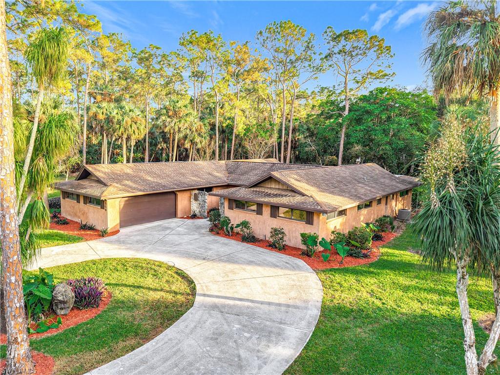 View of front of house with a garage and a front lawn