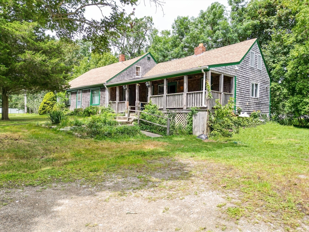 a view of a house with a yard and potted plants