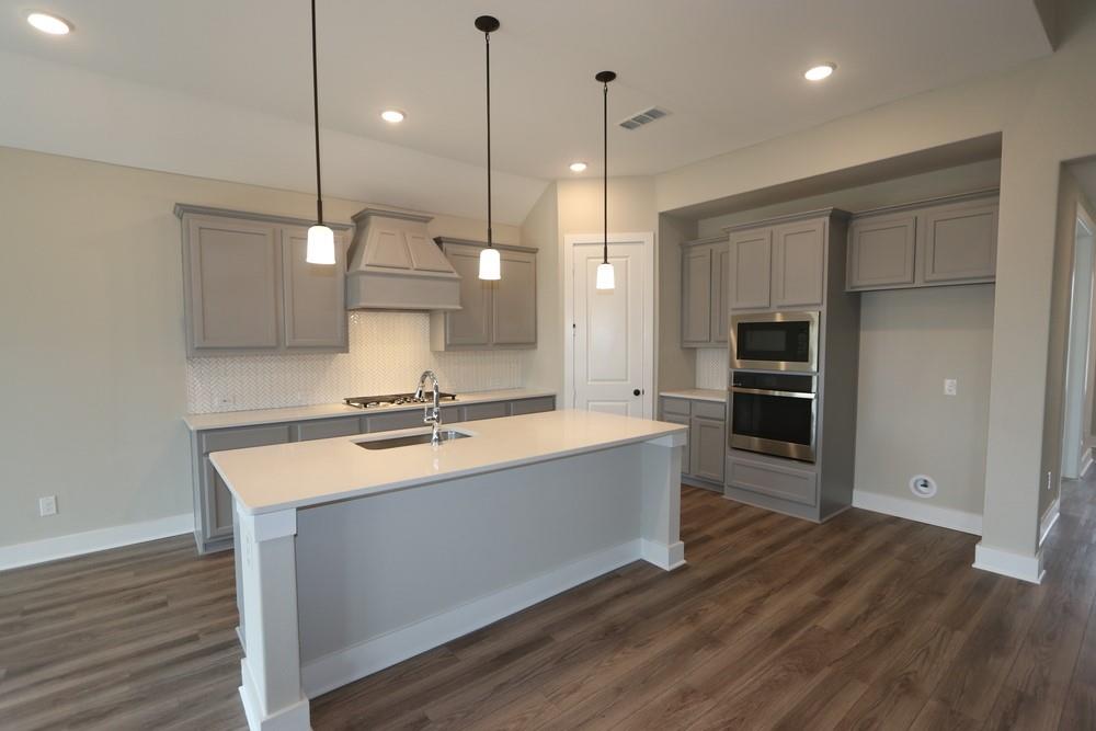 a large kitchen with kitchen island a wooden floor