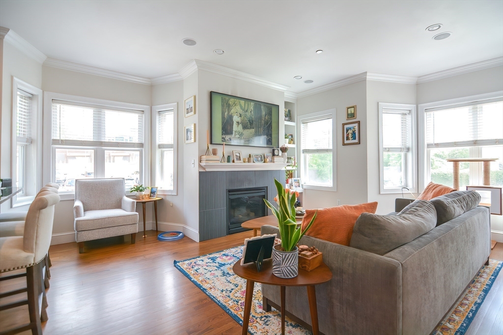 a living room with furniture a fireplace and a large window