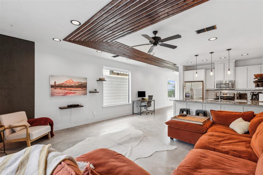 a living room with furniture kitchen view and a large window