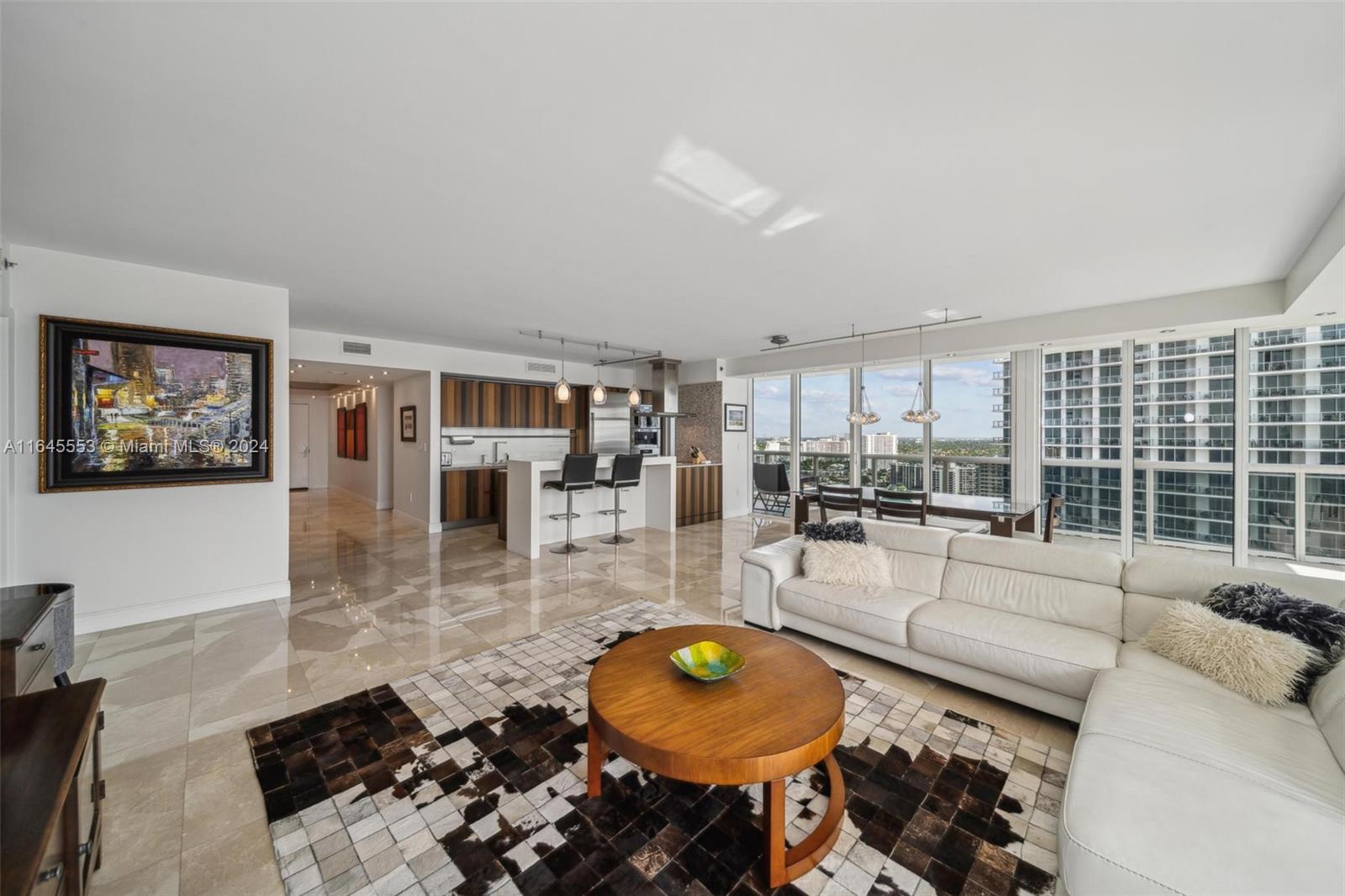 a living room with furniture and a floor to ceiling window