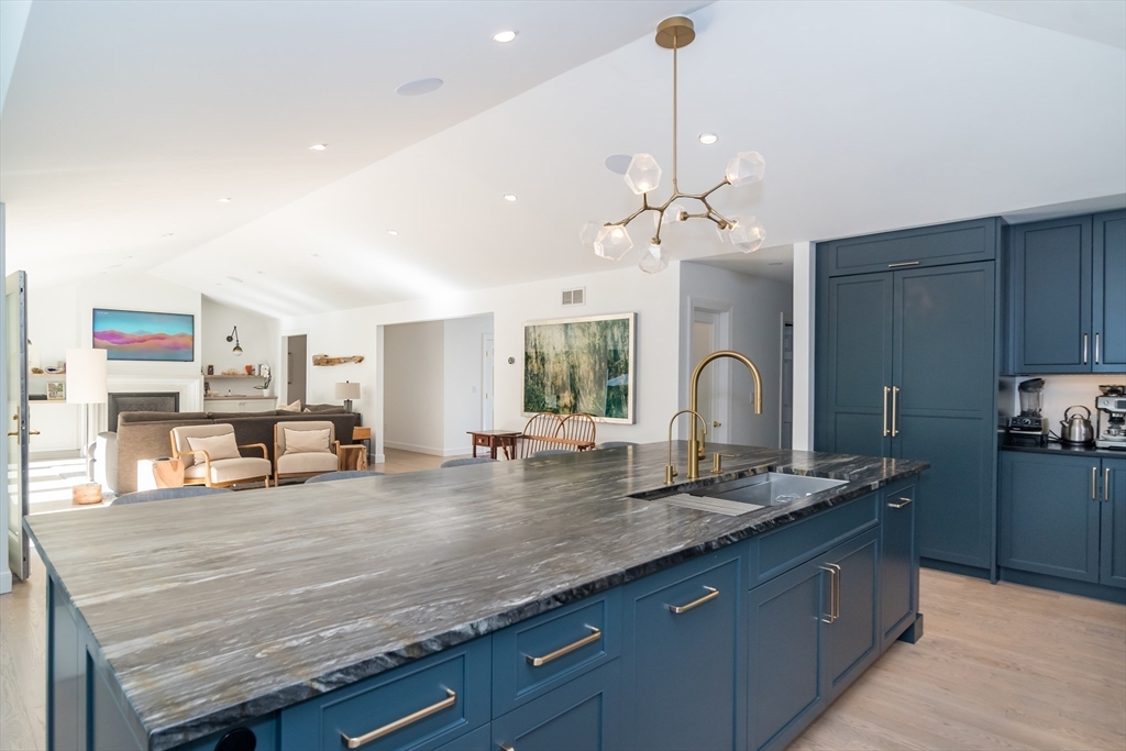 a large kitchen with granite countertop a stove and a sink