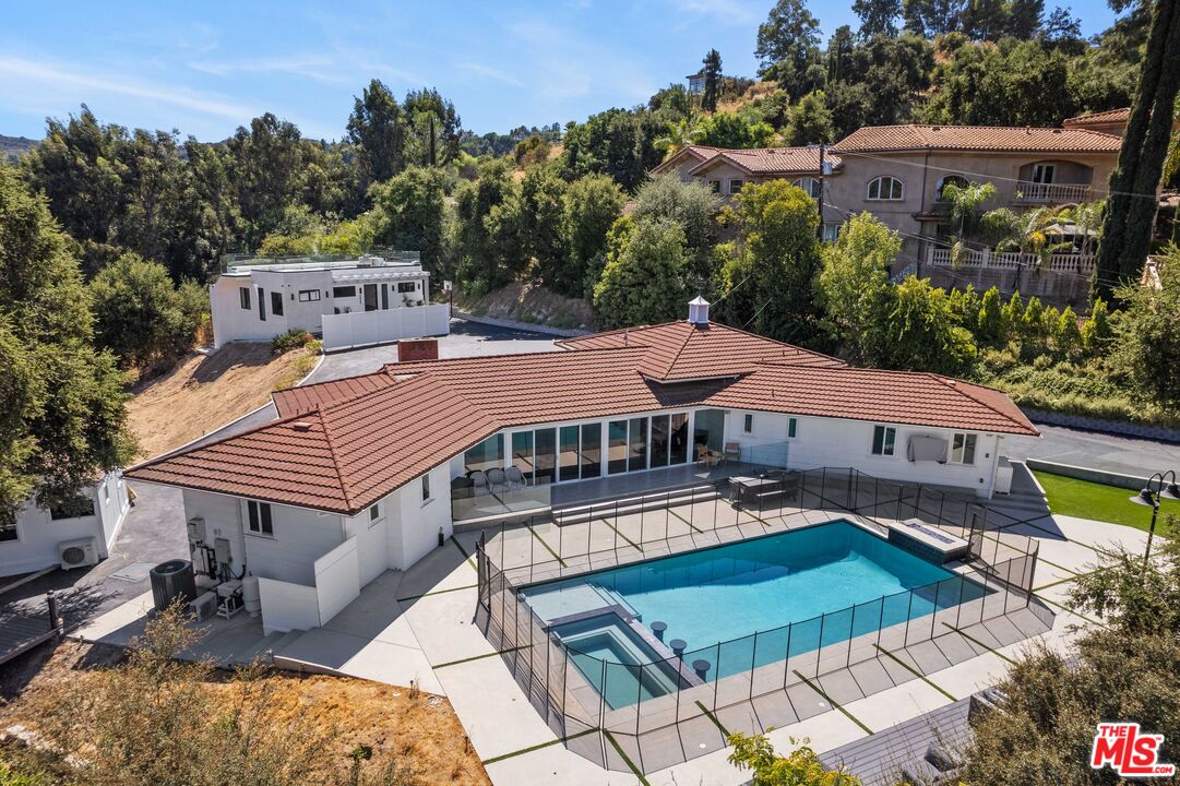 an aerial view of a house with swimming pool and sitting area