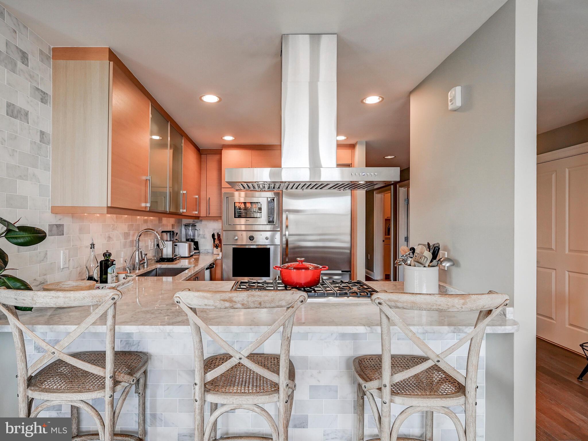 a kitchen with stainless steel appliances kitchen island granite countertop a table and chairs