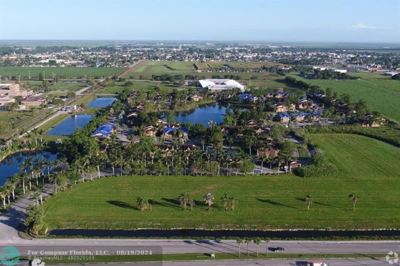 an aerial view of a residential houses with outdoor space and trees