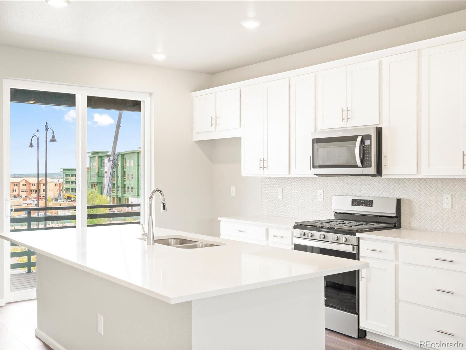 a kitchen with granite countertop a stove and a sink