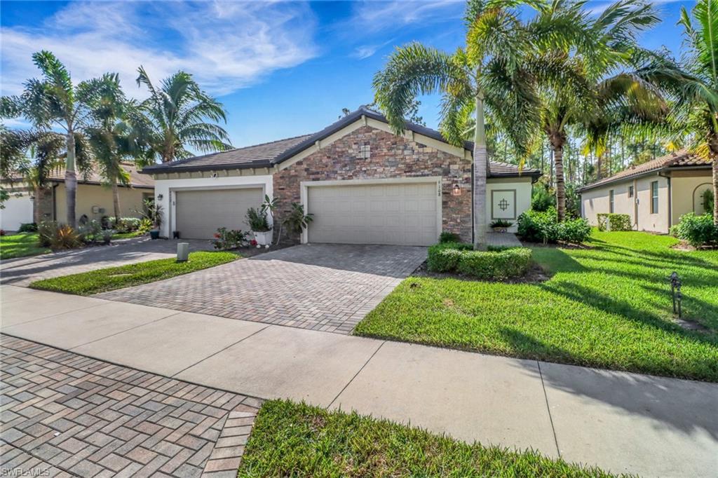 View of front of property featuring a garage and a front lawn