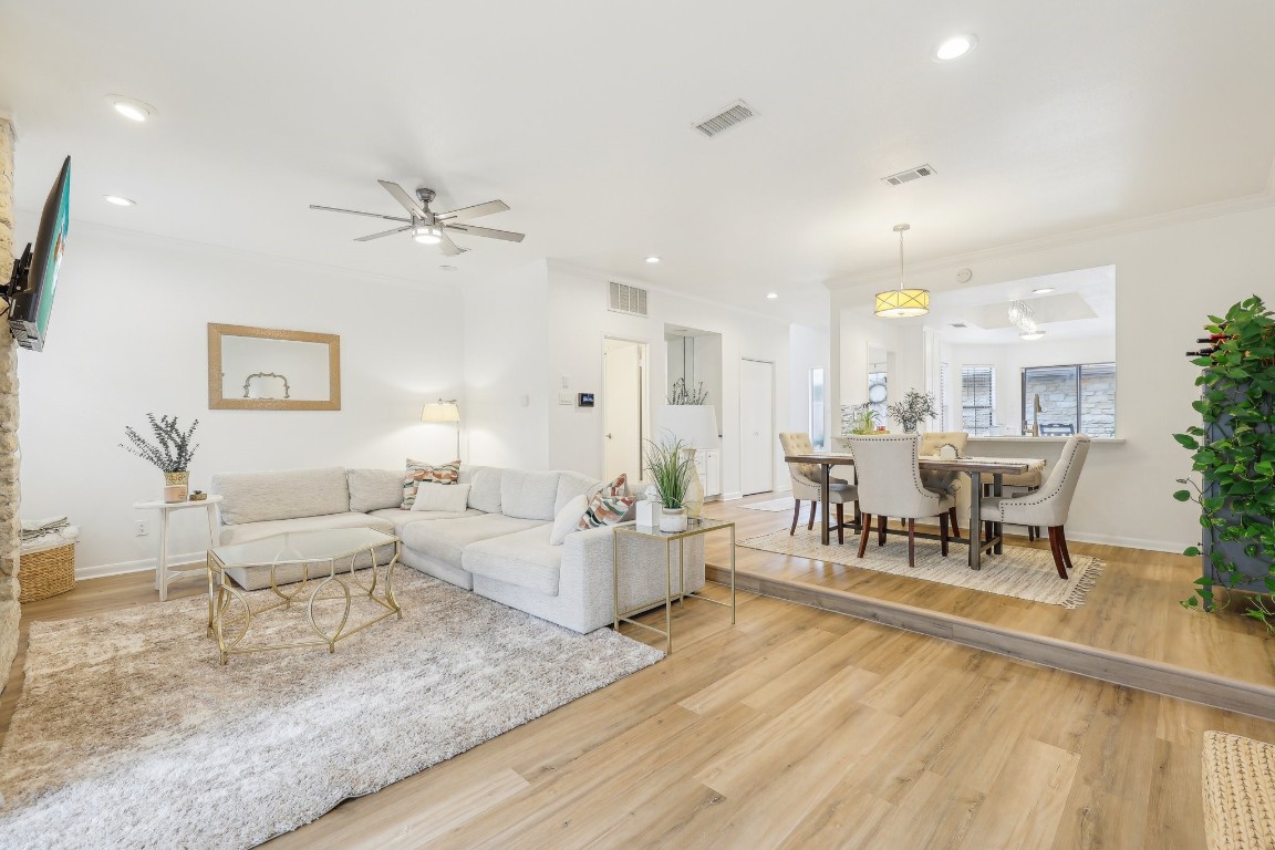 a living room with furniture and a dining table with kitchen view