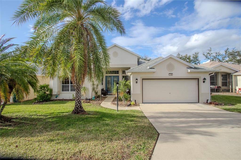 a view of a house with a yard and palm trees