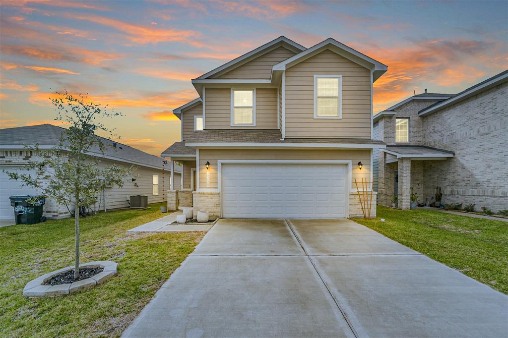 a front view of a house with a yard and garage