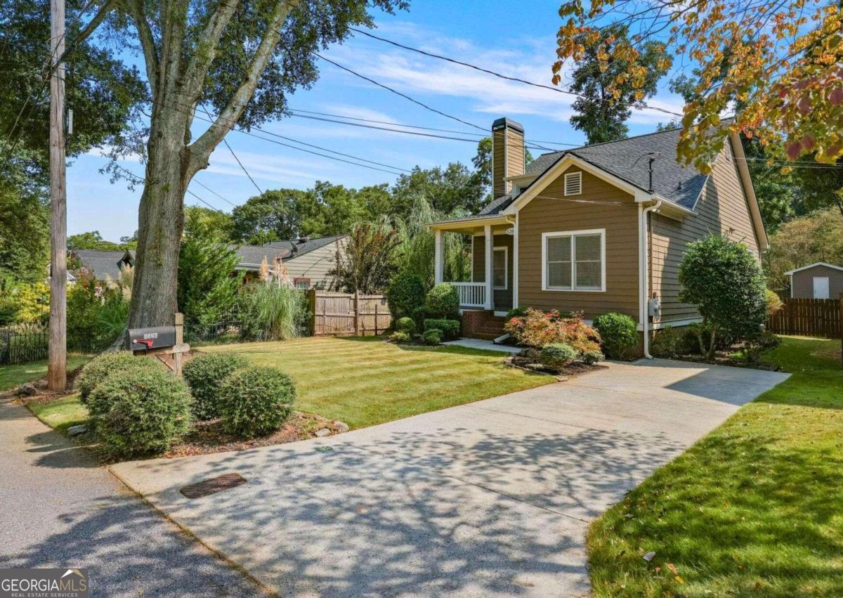 a front view of a house with a yard and potted plants