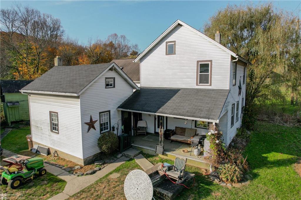 a aerial view of a house with yard porch and furniture