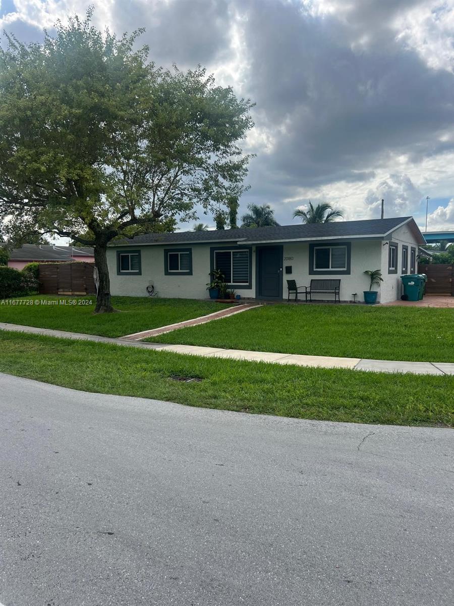 a front view of a house with a yard and trees