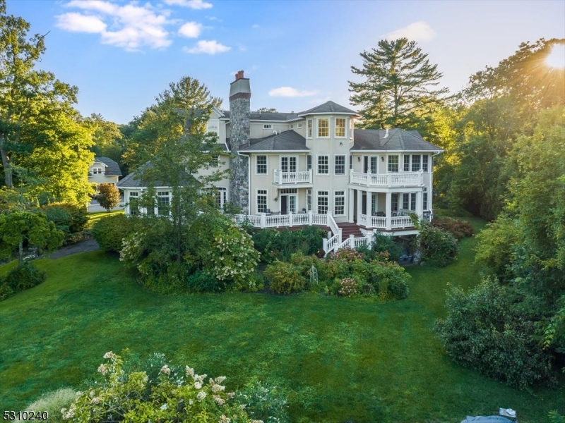 a view of a big yard in front of a brick house with a large tree