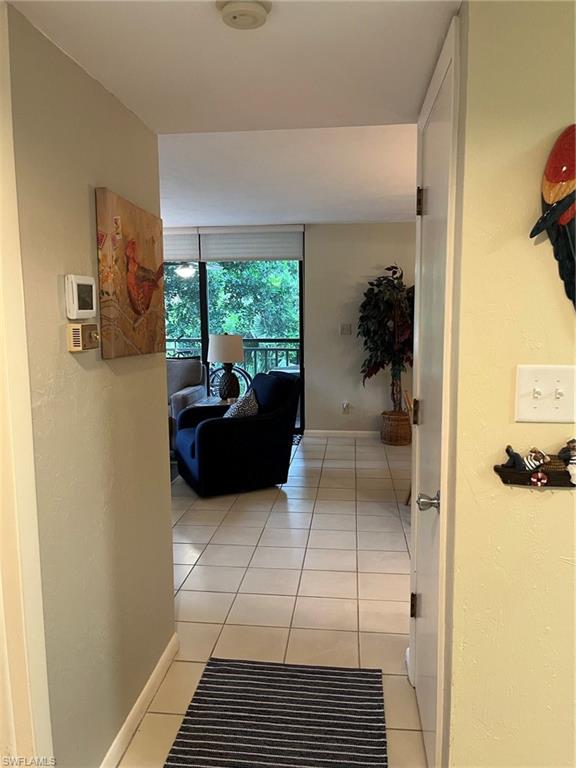 Dining space opens to living room and kitchen with breakfast bar featuring light tile patterned floors