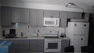 a kitchen with stainless steel appliances white cabinets sink and a refrigerator