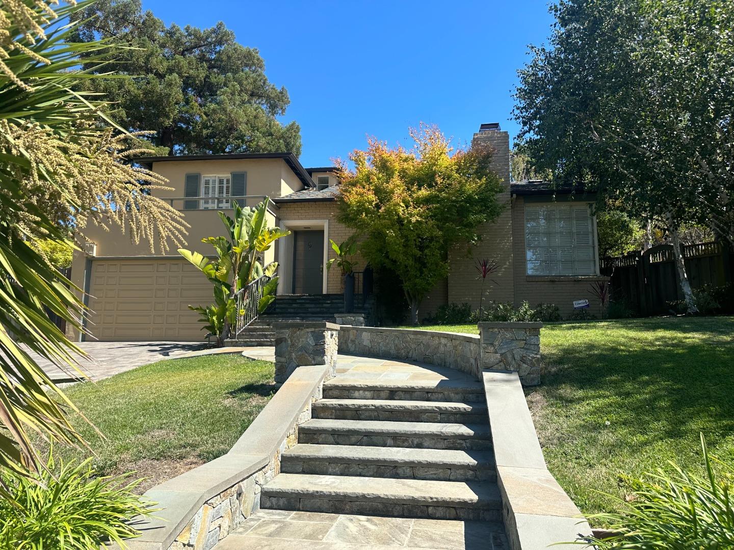 a view of a house with a yard patio and a fountain