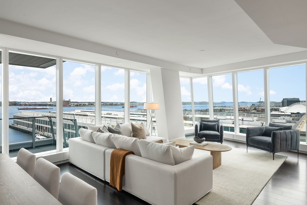 a living room with furniture and floor to ceiling windows