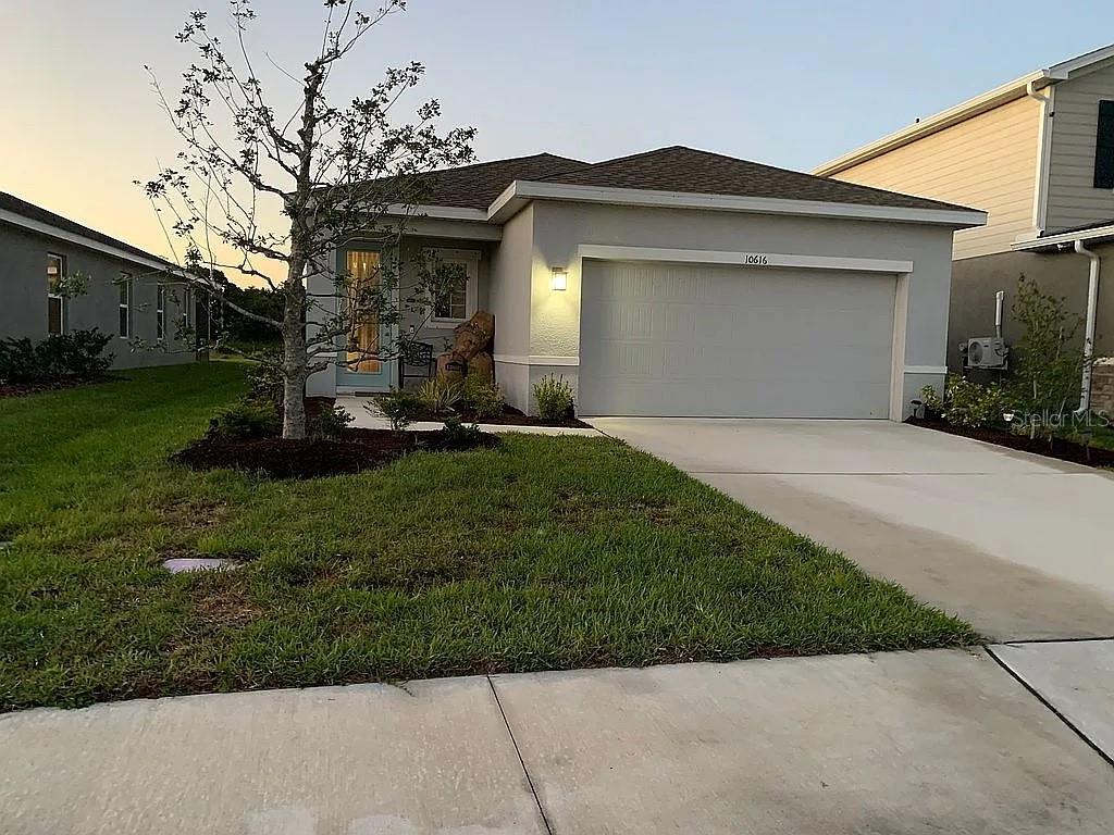 a front view of a house with a yard and garage