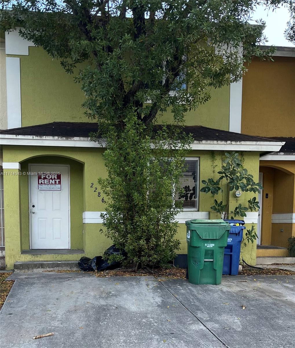 a front view of a house with plants