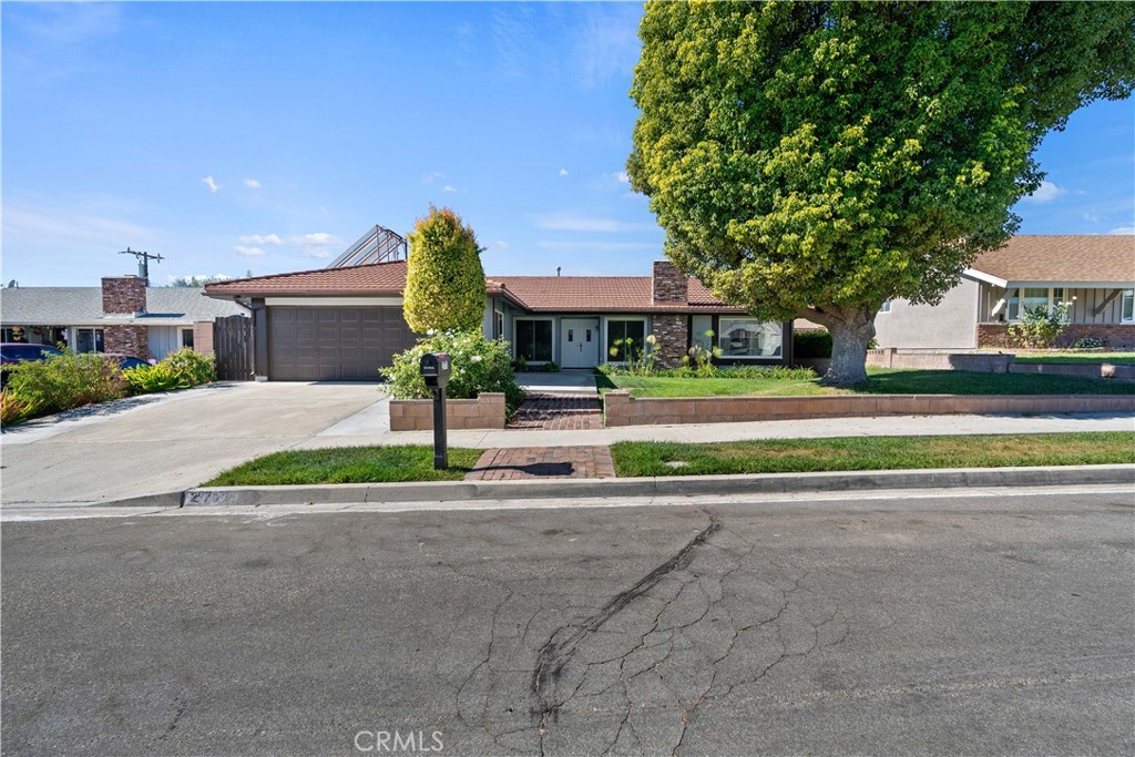 a front view of a house with a yard and road