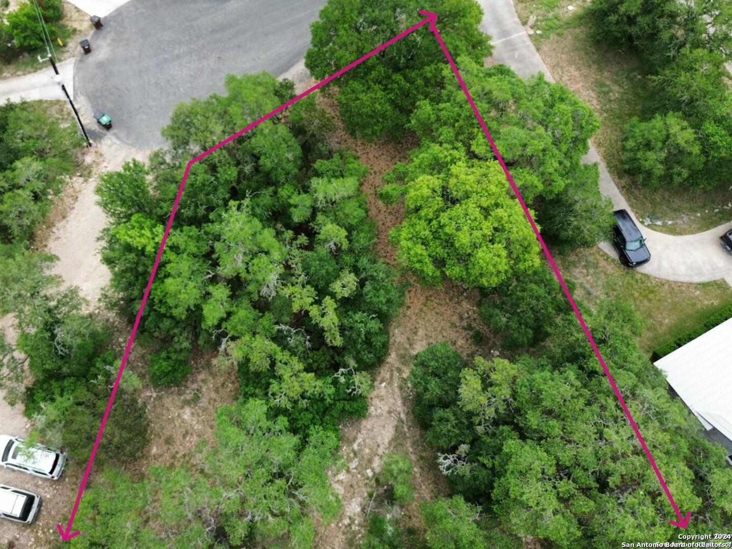 an aerial view of residential house with outdoor space and trees all around