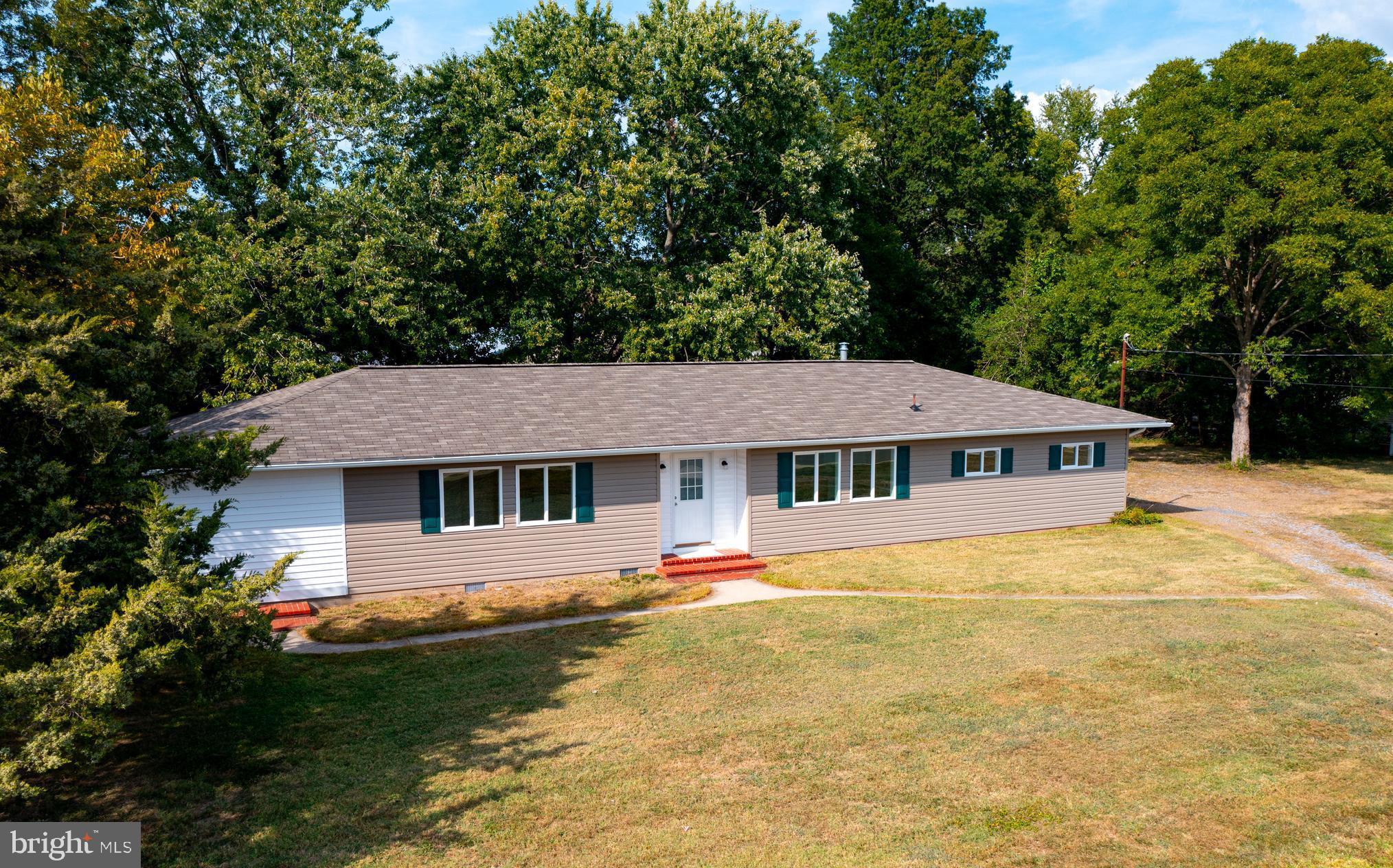 a front view of a house with yard and green space