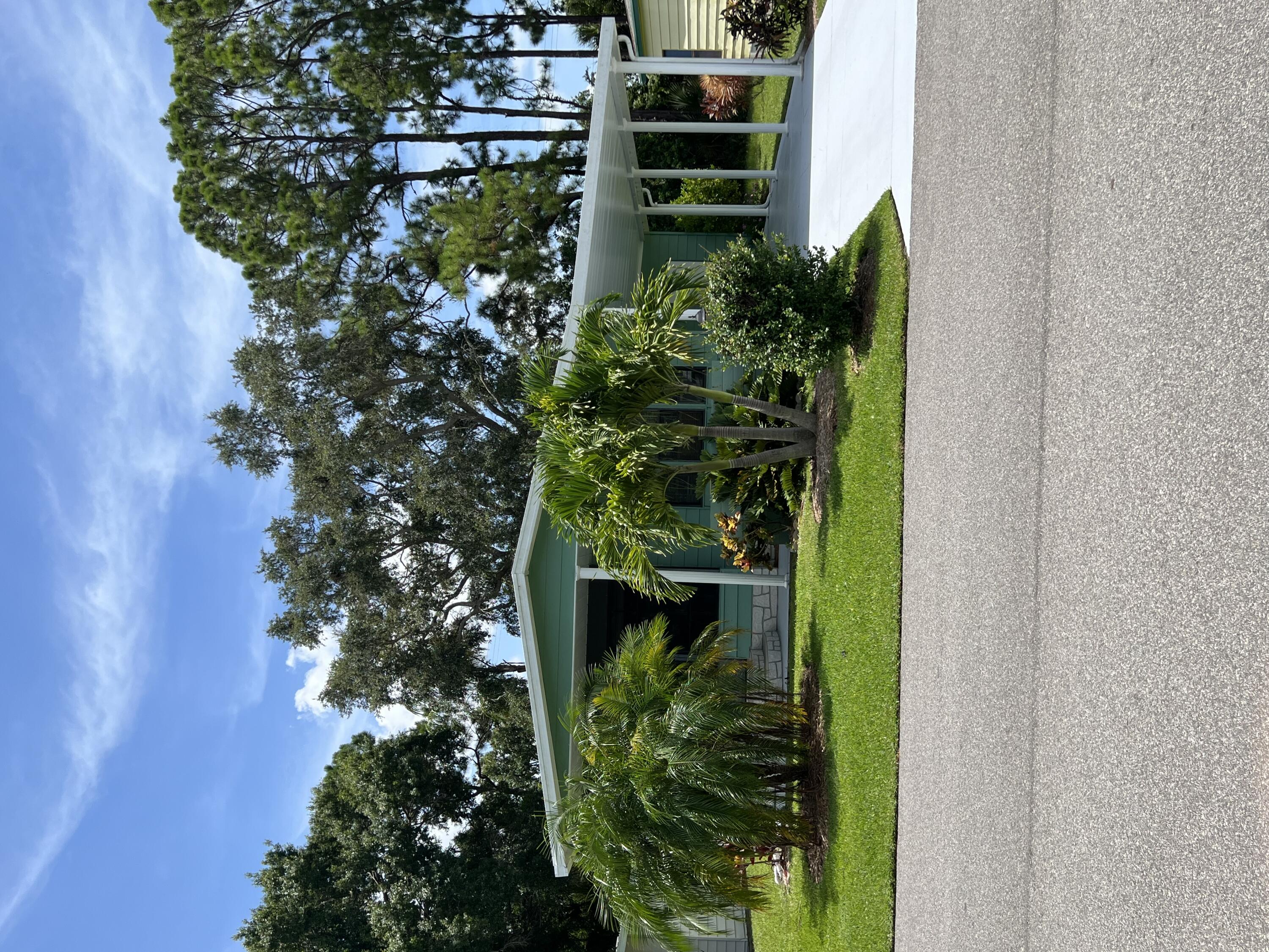 a view of a house with a yard and potted plants