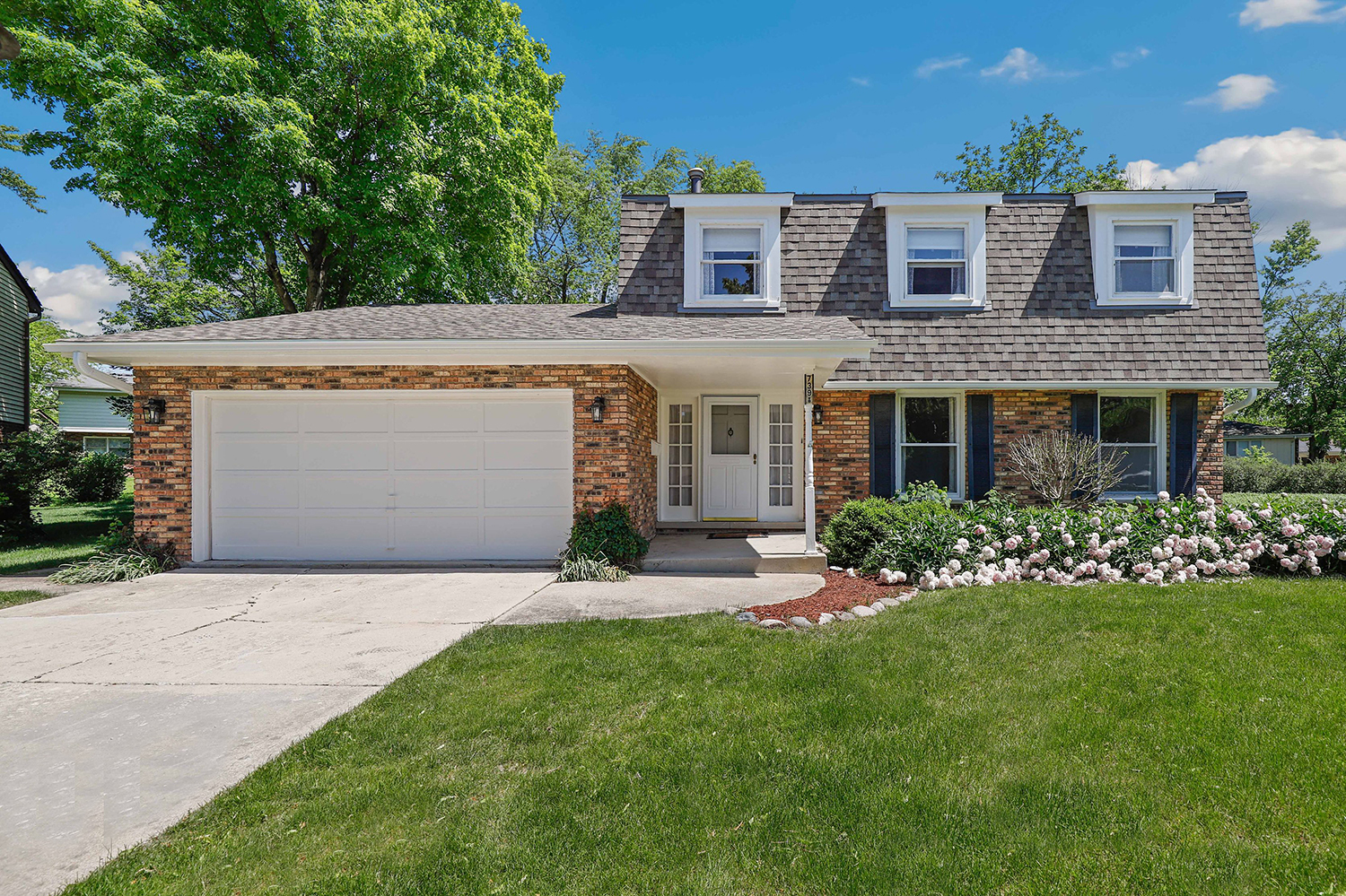 a front view of a house with a garden and yard