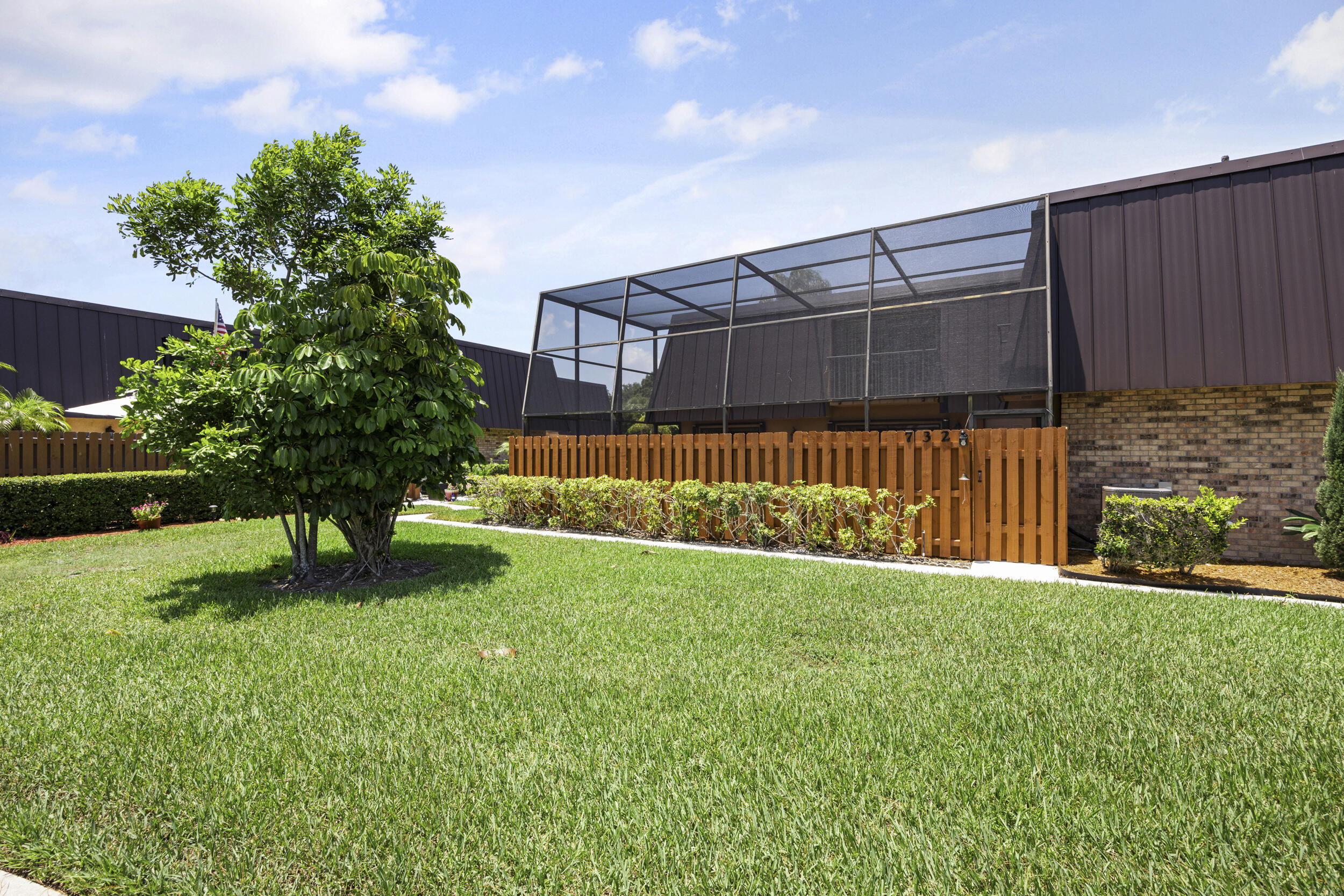 a view of a backyard with a small garden and wooden fence