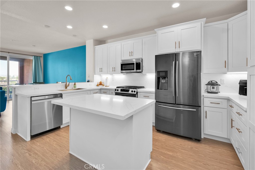 a kitchen with stainless steel appliances a refrigerator sink and microwave