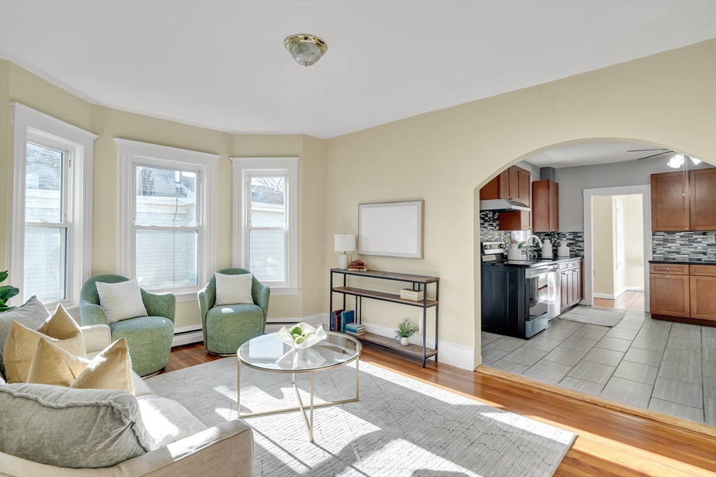 a living room with furniture and a wooden floor