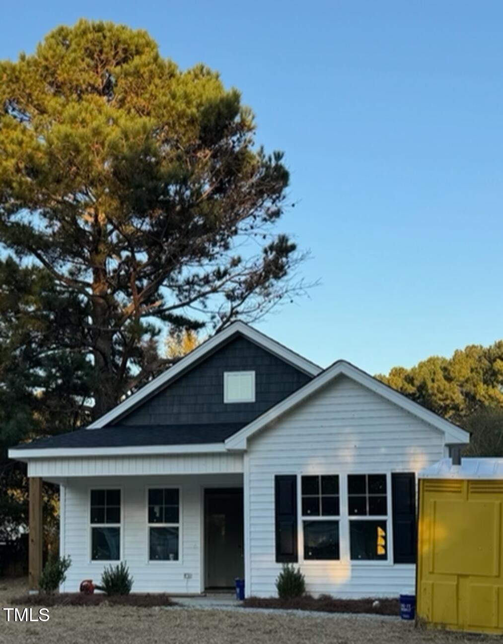 a front view of a house with a tree