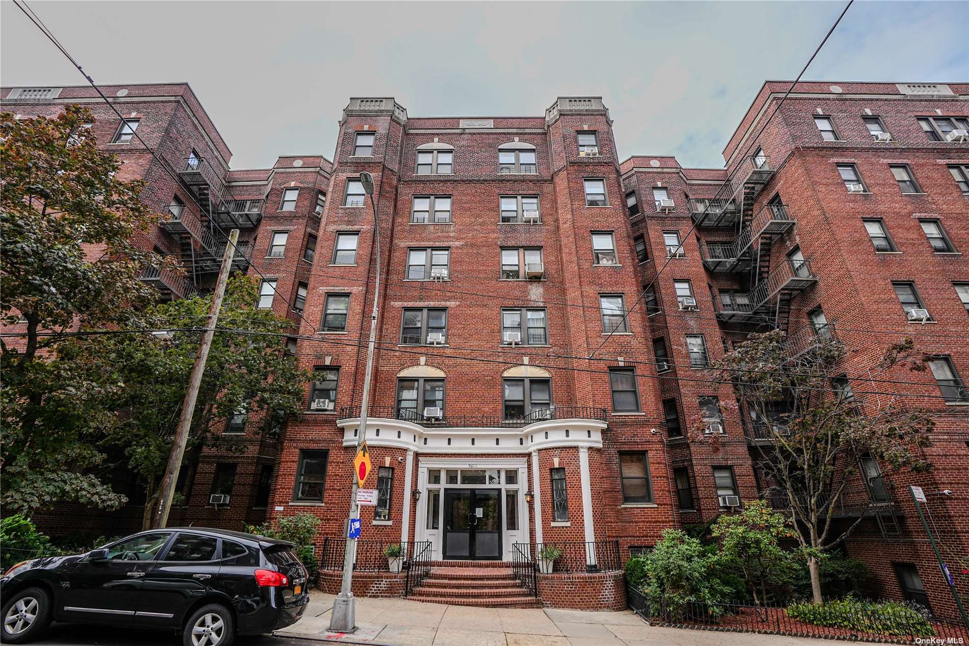 a front view of a multi story building with yard