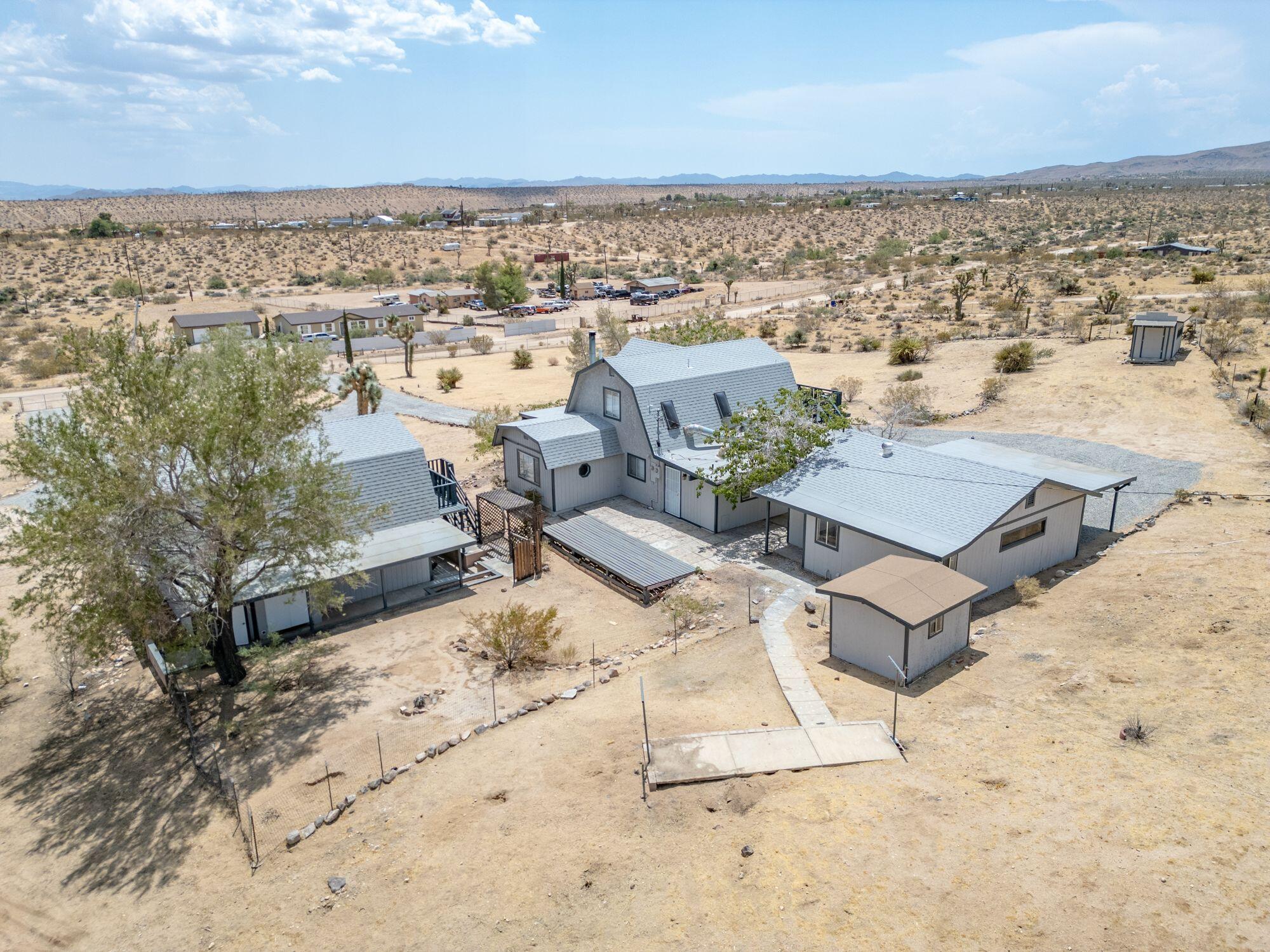 an aerial view of a house with a yard and ocean view in back