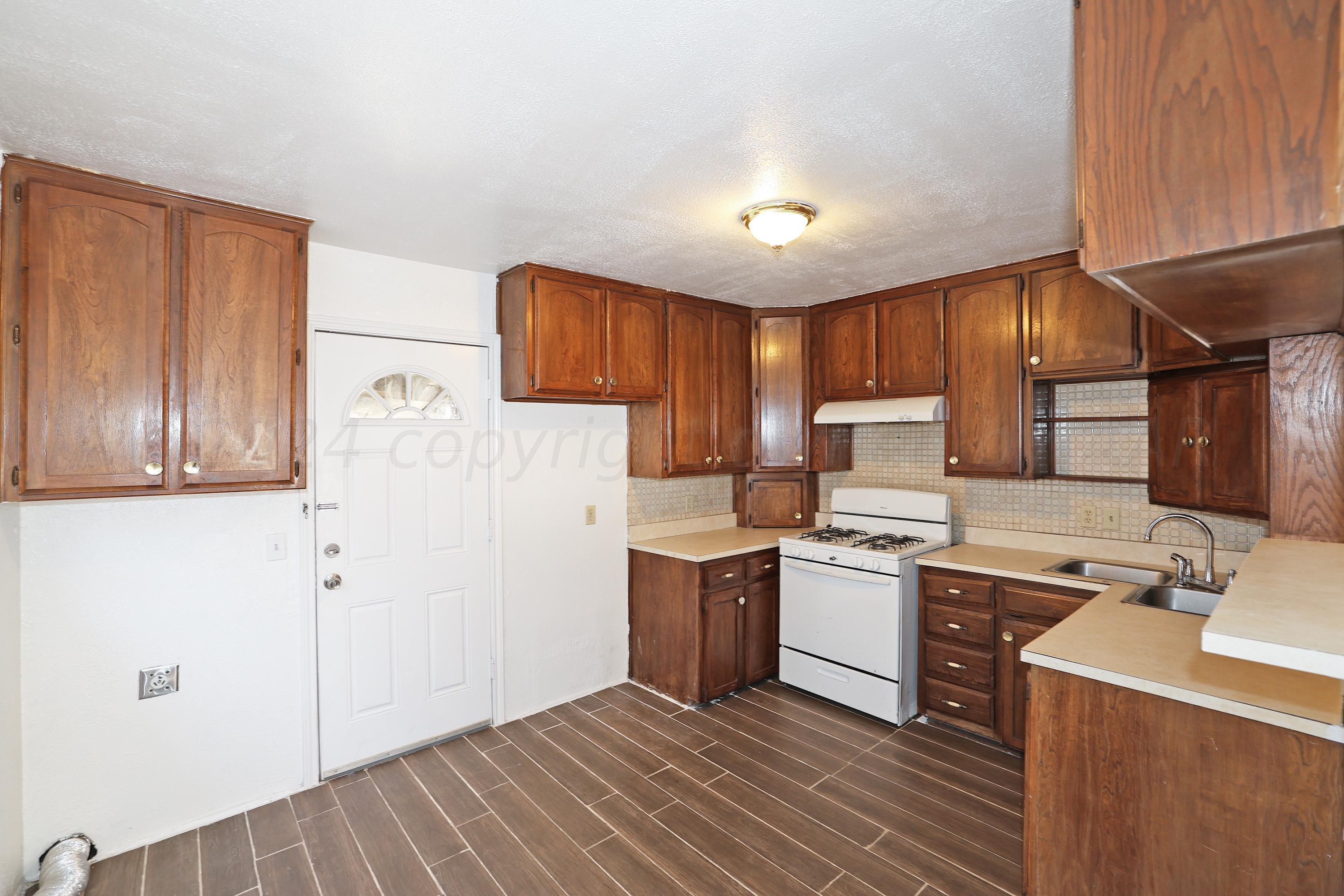 a kitchen with a stove a refrigerator and a sink