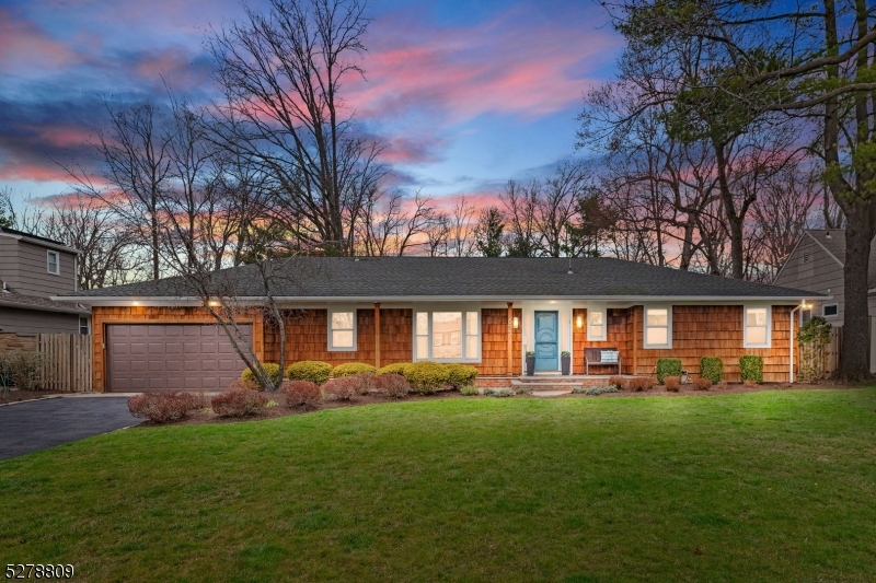 a front view of a house with a yard and outdoor seating