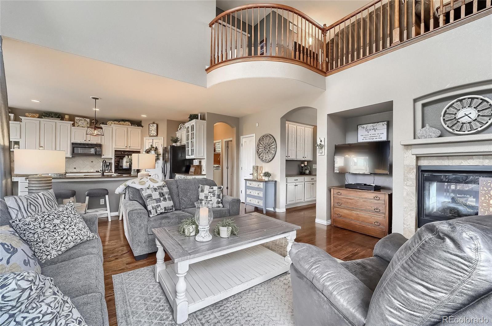 a living room with furniture a fireplace and kitchen view