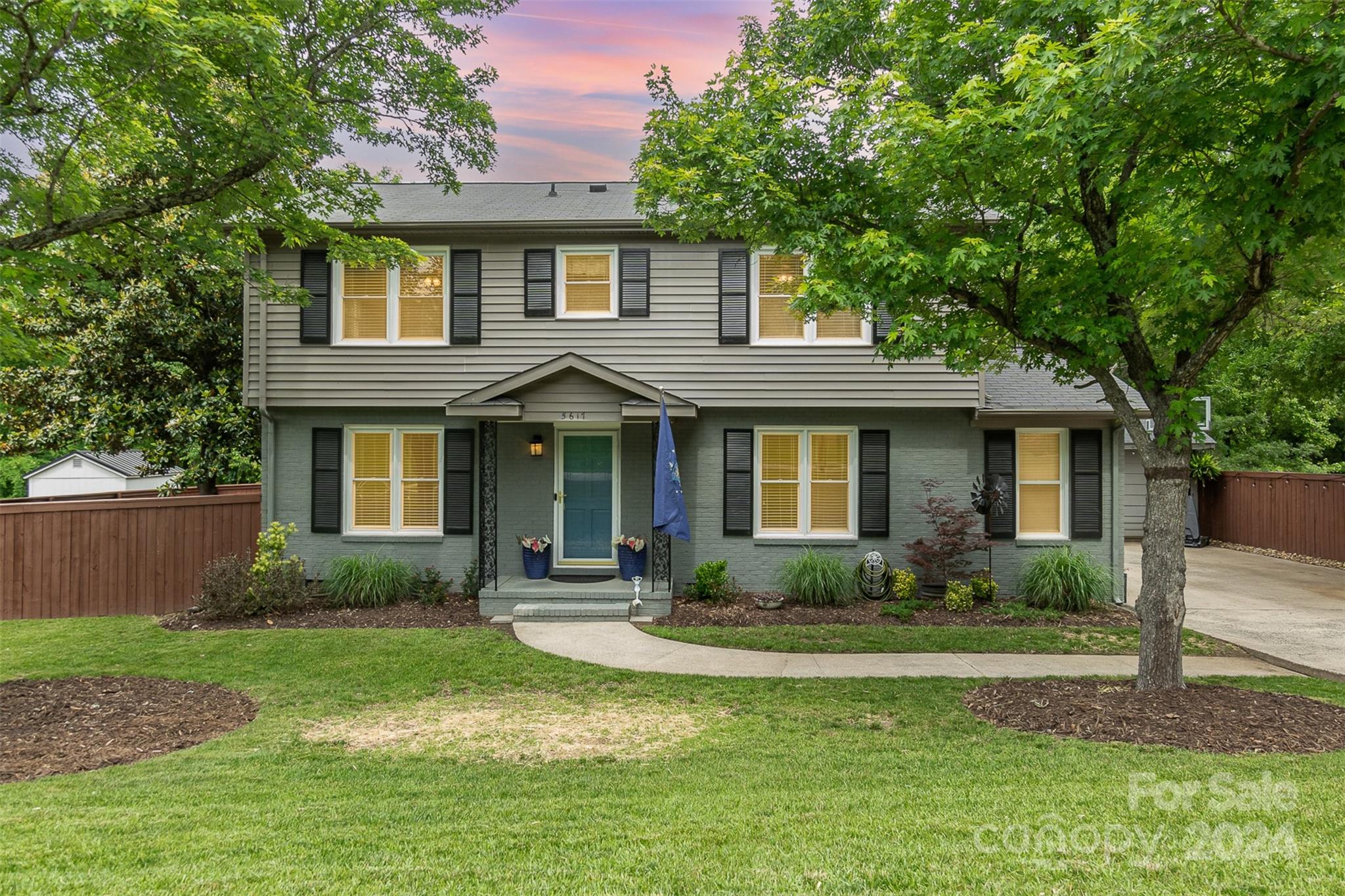 a front view of a house with a yard and potted plants